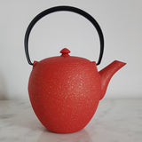 théière en fonte rouge et or